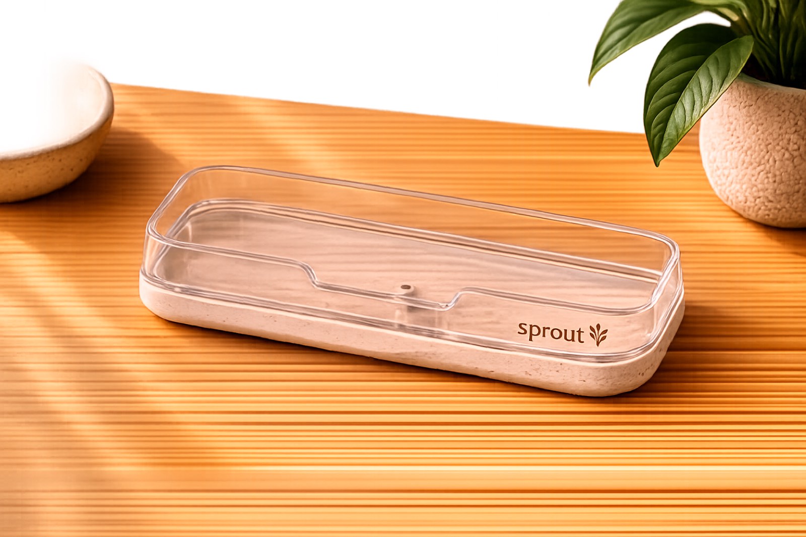 Sprout TeleWorks clear cradle, empty, photographed on a warm wood-slat surface.